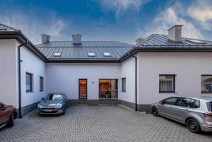 クリニツァ・ズドルイにあるApartament Krynica Centralの白い家の前に停められた車2台