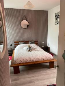 a bedroom with a bed with a teddy bear on it at Agréable maison de ville in LʼAigle