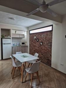 a dining room with a table and chairs and a brick wall at Pleno centro con cochera in San Salvador de Jujuy