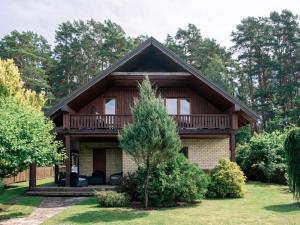 a log home with a balcony and a deck at Domus Revado in Birštonas