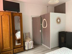 a bedroom with a bed and a dresser and a mirror at Agréable maison de ville in LʼAigle