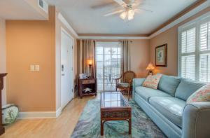a living room with a couch and a table at Driftwood Villa 101 by Carolina Beach Realty in Carolina Beach