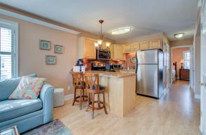 a living room with a kitchen with a refrigerator at Driftwood Villa 101 by Carolina Beach Realty in Carolina Beach