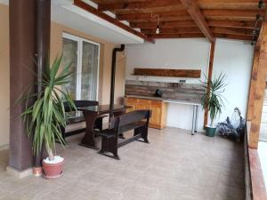 a patio with a wooden table and a bench and a table at Path ways to the Sea -Пътека към морето in Primorsko
