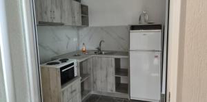 una cucina con un frigorifero bianco e un lavello di Prionas Studios a Paralía Skotínis Altre 23 foto