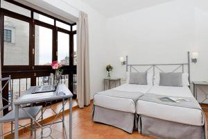 Postel nebo postele na pokoji v ubytování Sercotel Toledo Imperial