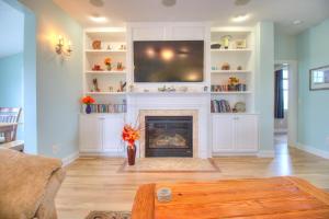 a living room with a fireplace and a flat screen tv at Elanora by Carolina Beach Realty in Kure Beach