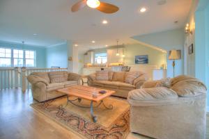a living room with two couches and a coffee table at Elanora by Carolina Beach Realty in Kure Beach