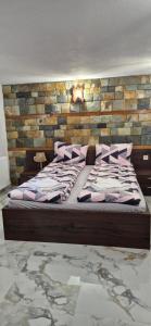 a bed in a room with a brick wall at Къща за гости Брязово in Ribarica +34 photos
