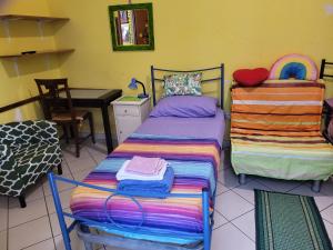 a room with two beds and a desk and a table at Bed-Letto-Cama in Shared Room Camera Condivisa in Naples +3 photos