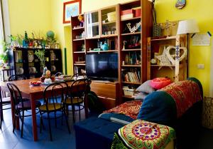 a living room with a table and a tv at Bed-Letto-Cama in Shared Room Camera Condivisa in Naples
