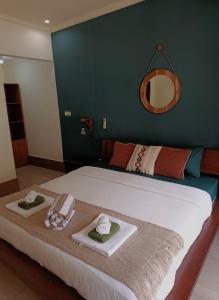 a bedroom with a bed with towels and a mirror at TT House Gili Air in Gili Islands +31 photos