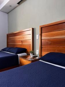 a bedroom with two beds and wooden headboards at Hotel Boutique Blue Diamond in Tepatitlán de Morelos