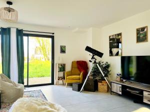 ein Wohnzimmer mit einem TV und einem gelben Stuhl in der Unterkunft Brikenn - Ideal Country Loft for Families & Couples in Trébeurden