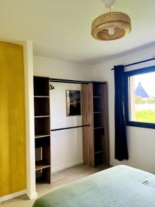 ein Schlafzimmer mit einem Bett, einem Fenster und Regalen in der Unterkunft Brikenn - Ideal Country Loft for Families & Couples in Trébeurden