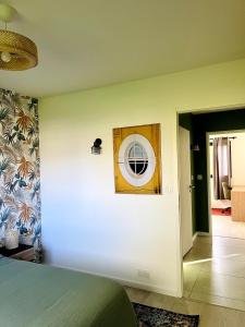 ein Schlafzimmer mit einem Bett und einem Spiegel an der Wand in der Unterkunft Brikenn - Ideal Country Loft for Families & Couples in Trébeurden + 16 Fotos