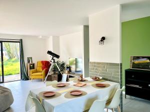 ein Wohnzimmer mit einem Tisch mit Stühlen und einer Kamera in der Unterkunft Brikenn - Ideal Country Loft for Families & Couples in Trébeurden