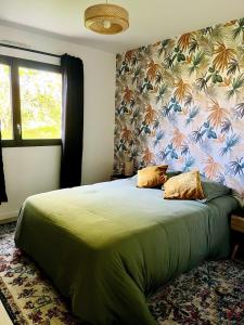 ein Schlafzimmer mit einem grünen Bett mit Blumentapete in der Unterkunft Brikenn - Ideal Country Loft for Families & Couples in Trébeurden