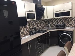 a kitchen with a sink and a washer and dryer at Хорошем месте находится, улица Иззет Небиев 6-22 in Baku