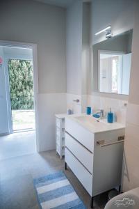 a white bathroom with a sink and a mirror at San Martino Lake Como Holiday House in Griante Cadenabbia