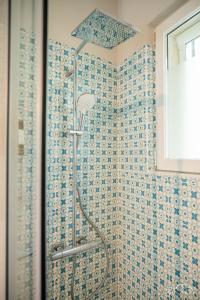 a shower in a bathroom with blue and white tiles at San Martino Lake Como Holiday House in Griante Cadenabbia +43 photos