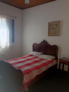 a bedroom with a bed with a striped blanket at Encanto Mada´s Itamambuca in Ubatuba
