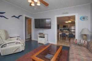 a living room with a couch and a flat screen tv at Hunnicutt House by Carolina Beach Realty in Kure Beach
