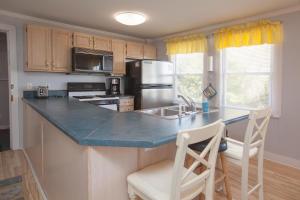 a kitchen with a counter with a refrigerator and a sink at Hunnicutt House by Carolina Beach Realty in Kure Beach