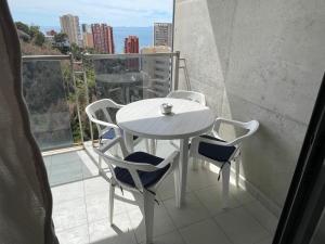 une table blanche et des chaises sur un balcon dans l'établissement apartamento con vistas y bien ubicado renovado, à Benidorm 1 autre photo