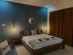 a bedroom with a large bed with a blue wall at TT House Gili Air in Gili Islands