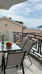a patio with a table and chairs on a balcony at Tafra apartmani Igalo in Igalo