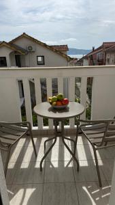 a bowl of fruit on a table on a balcony at Tafra apartmani Igalo in Igalo