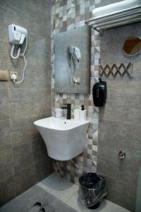 a bathroom with a sink and a phone on the wall at Quiet Studio with Smart Entry Roses in Jeddah