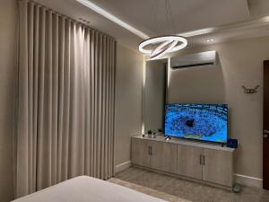 a room with a bed and a tv and curtains at Quiet Studio with Smart Entry Roses in Jeddah +9 photos