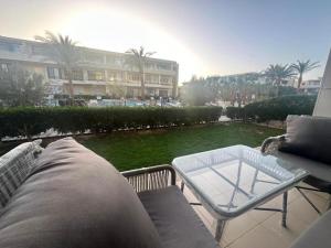 d'une terrasse avec un canapé et une table sur un balcon. dans l'établissement Hotel Apartment in G cribs, à Hurghada