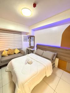 宿务Classy Gabi's Crib - Horizon 101的带一张大床和一张沙发的卧室