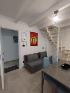 a living room with a couch and a staircase at "Antica Dimora" - Appartamenti Turistici Nuovi a Gravina in Puglia - con Parcheggio Gratuito su Strada in Gravina in Puglia