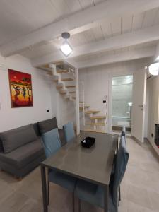 a living room with a table and a couch and stairs at "Antica Dimora" - Appartamenti Turistici Nuovi a Gravina in Puglia - con Parcheggio Gratuito su Strada in Gravina in Puglia