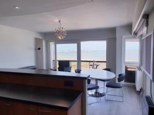 a kitchen and dining room with a view of the ocean at SeaStay - vernieuwde badkamer en interieur living in Knokke-Heist