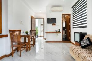 a living room with a table and chairs and a television at cmb apartments in Negombo