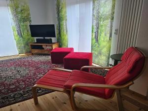 a living room with two chairs and a flat screen tv at Ferienhaus Zum roten Adler in Storkow in Storkow