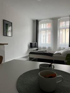 Habitación blanca con una taza de café sobre una mesa en Apartament Monstera II- top śniadanie, en Bydgoszcz