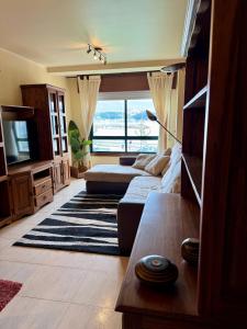 Una sala de estar con un sofá y un televisor. en Atalaya de Verano Bueu, en Bueu