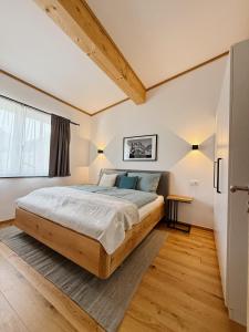 ein Schlafzimmer mit großem Bett und Holzboden in der Unterkunft Panoramablick Apartment Bad Aussee in Bad Aussee