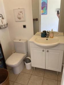 a white bathroom with a toilet and a sink at Crystal Beach, vue mer, accès direct plage et piscine, clim in Sèze