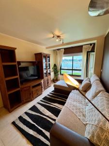 Una sala de estar con un sofá y un televisor. en Atalaya de Verano Bueu, en Bueu 48 fotos más