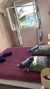 two beds in a room with a large window at Crystal Beach, vue mer, accès direct plage et piscine, clim in Sèze