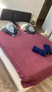a bed with a red blanket and two pillows on it at Crystal Beach, vue mer, accès direct plage et piscine, clim in Sèze
