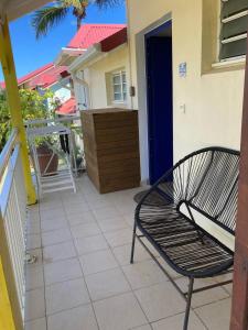 a black chair sitting on a patio with a house at Crystal Beach, vue mer, accès direct plage et piscine, clim in Sèze
