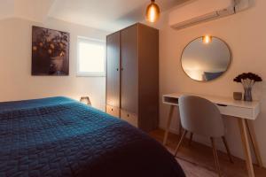 a bedroom with a bed and a desk and a mirror at Noahkis Apartments in Bad Ems